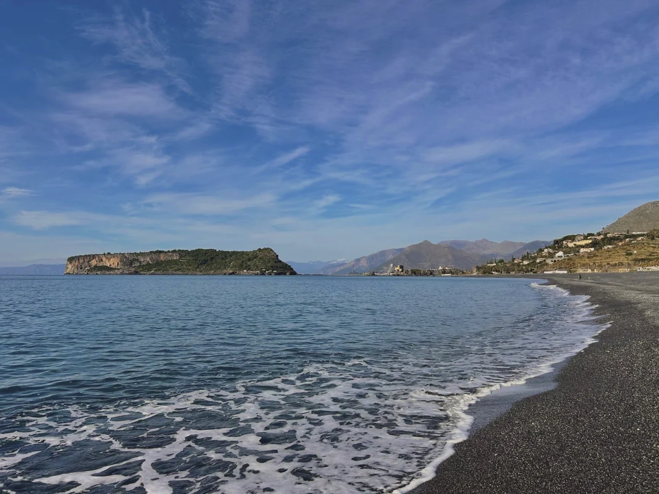 The shore in the evening, with the island of Dino beyond