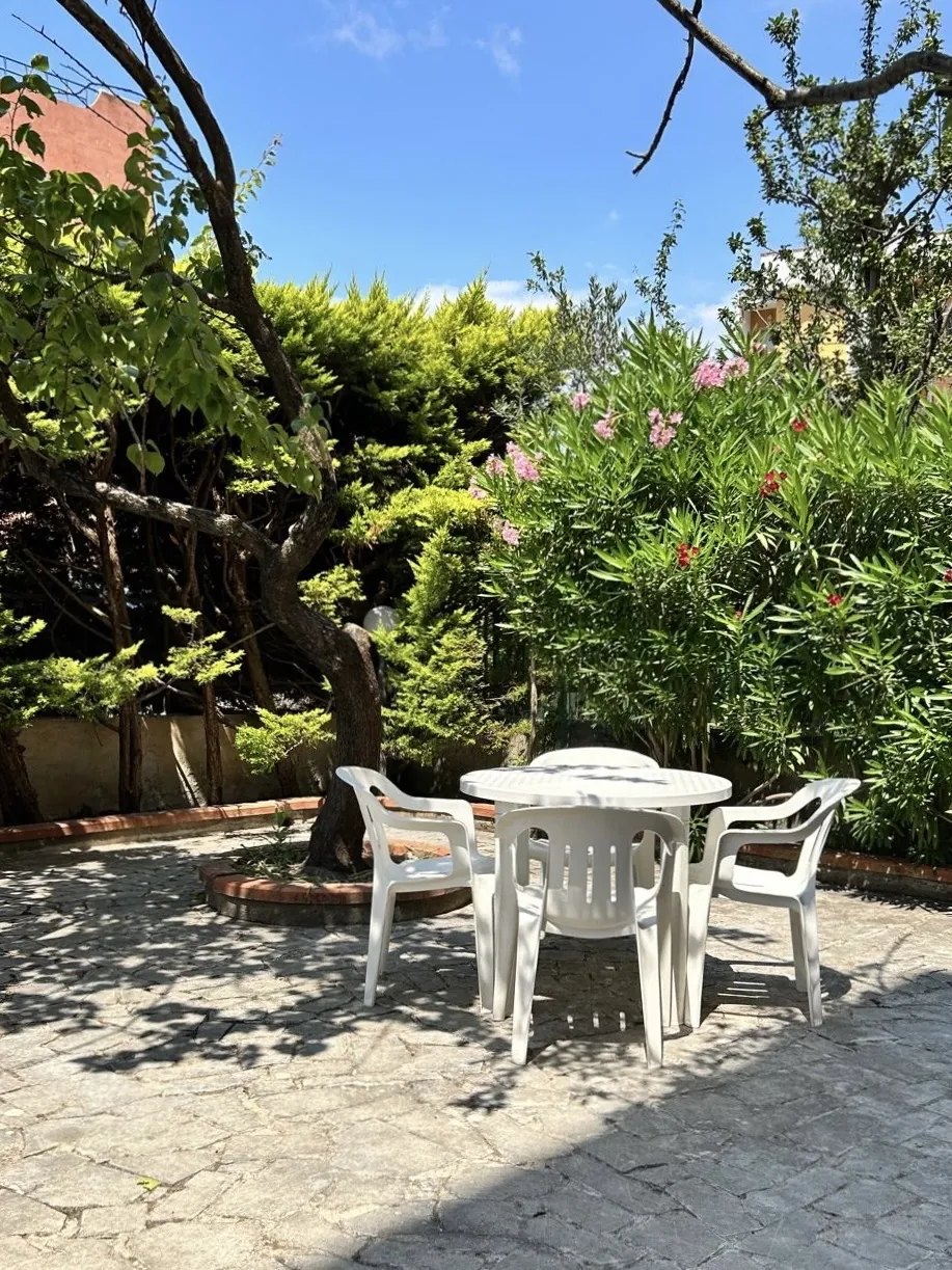 The garden: a table under the trees and flowering oleander
